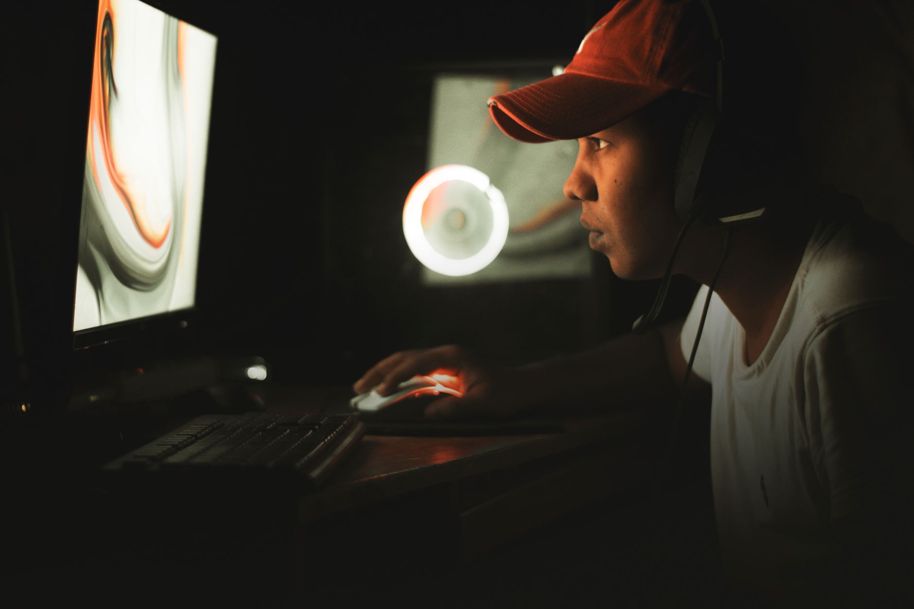 Joueur de jeux vidéo concentré sur son écran dans une pièce sombre